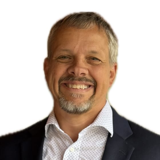 Tom Smith, founder of TomProtects, smiling in a navy blazer